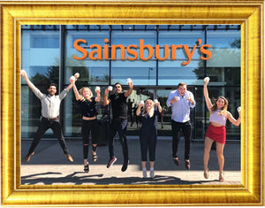 coconut merchant staff jumping in front of sainsburys whilst holding products