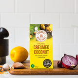 Coconut Merchant Organic Creamed Coconut 200g with fresh ginger red chili and spices on marble background