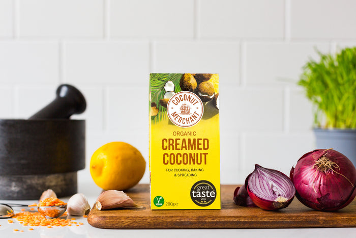 Coconut Merchant Organic Creamed Coconut 200g with fresh ginger red chili and spices on marble background
